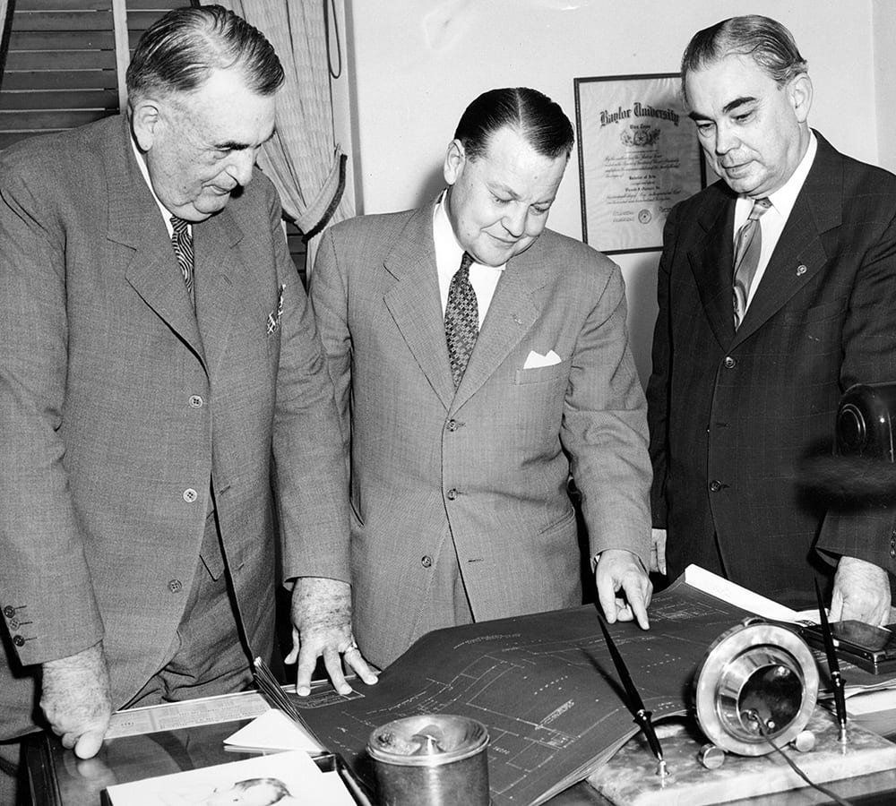 Frank Groner looking at blueprints with two colleagues