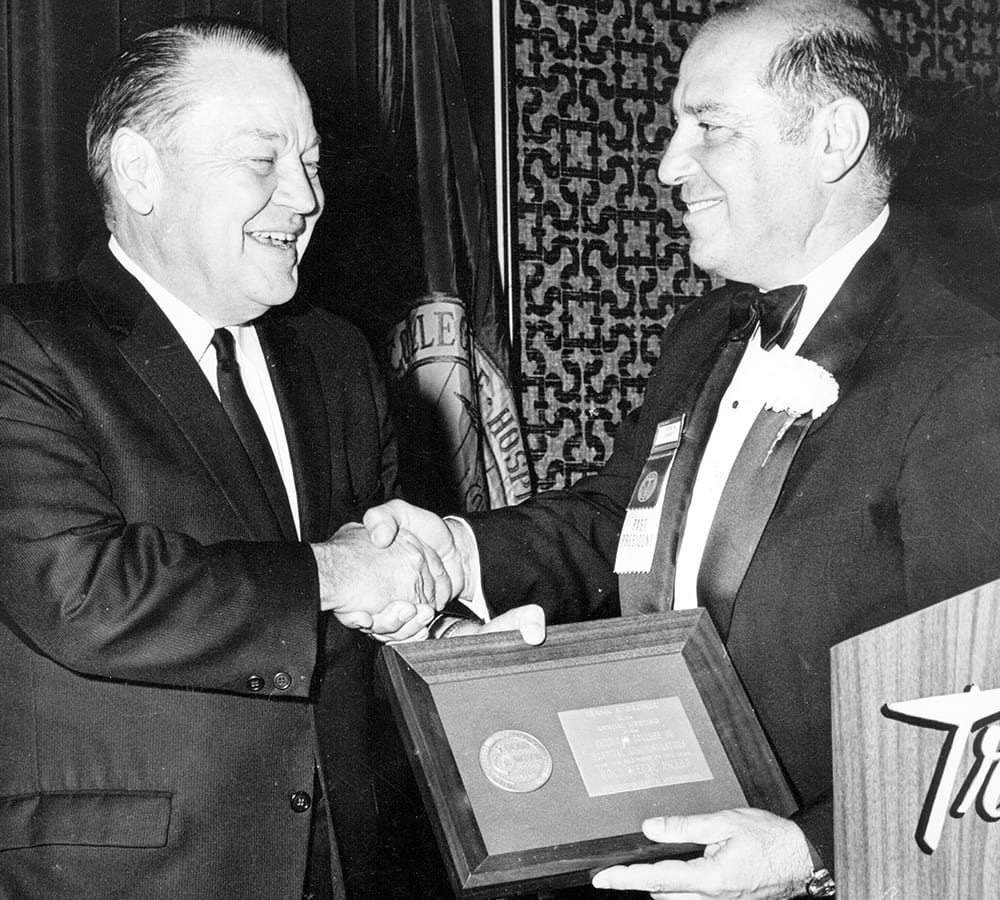 Frank Groner receiving an award and shaking a colleagues hand
