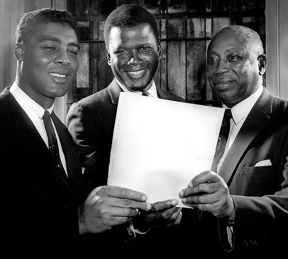 Matthew Walker Sr. holding up a piece of paper with two others
