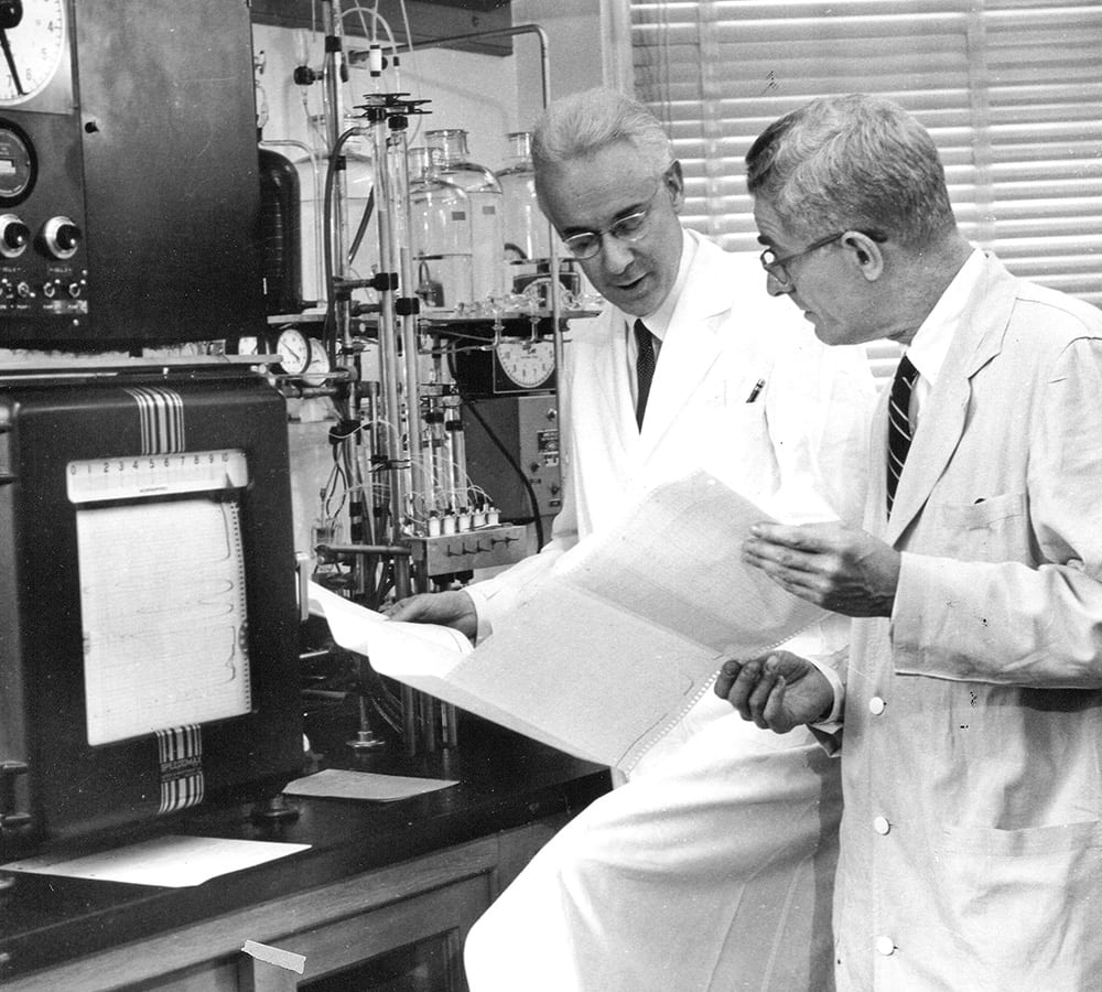 Stanford Moore looking at results with a colleague in a laboratory 